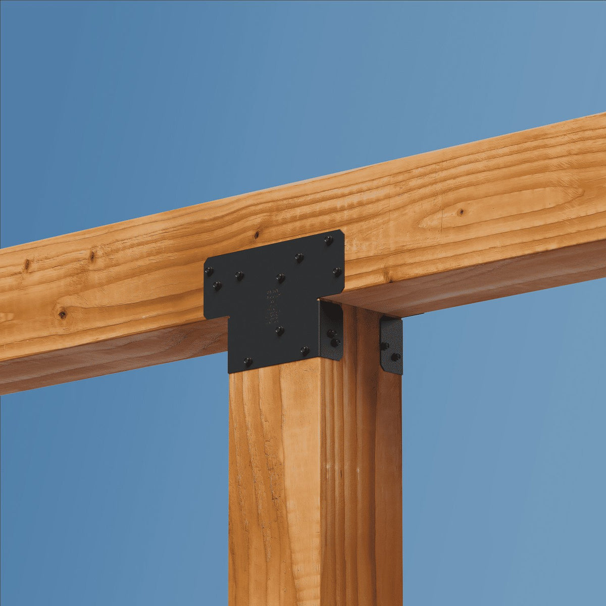 Wooden beams with a metal bracket against a blue sky