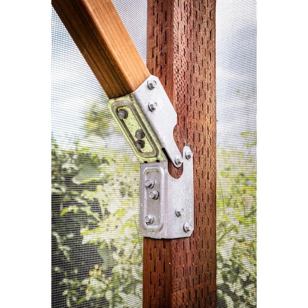Wooden handle with metal bracket attached to a wooden frame, with a blurred green outdoor background.
