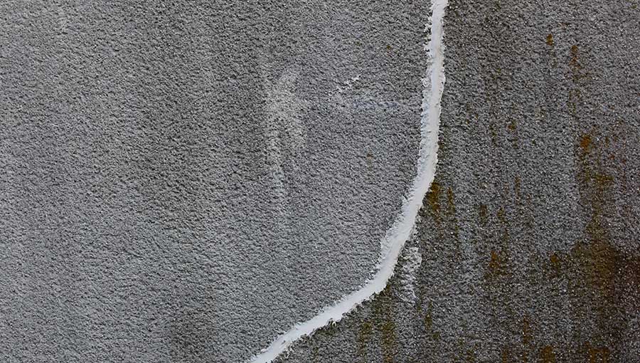 Concrete wall with crack repaired with white concrete