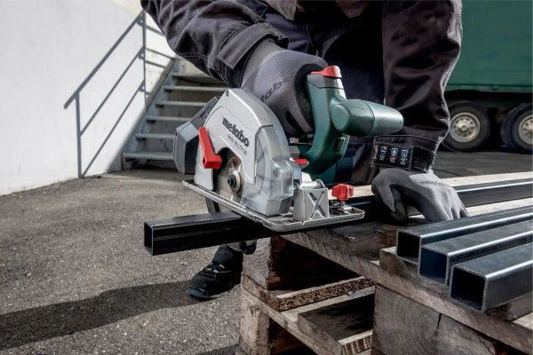 Person using a circular saw to cut metal on a construction site