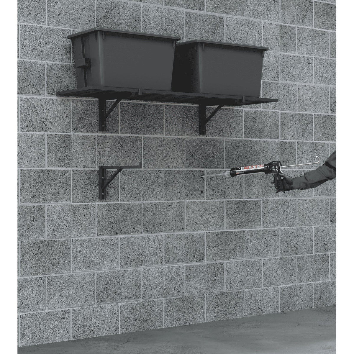 Person applying sealant to a brick wall with a caulking gun.