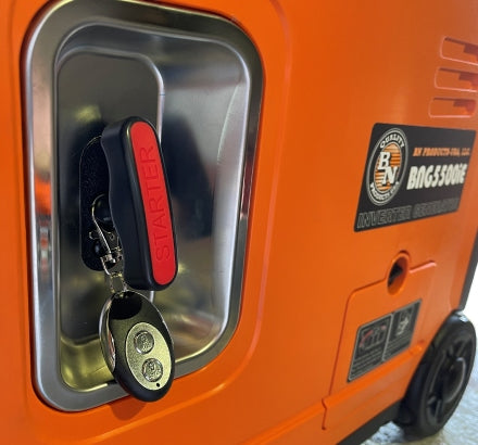 Orange generator with key and starter switch on a metallic surface