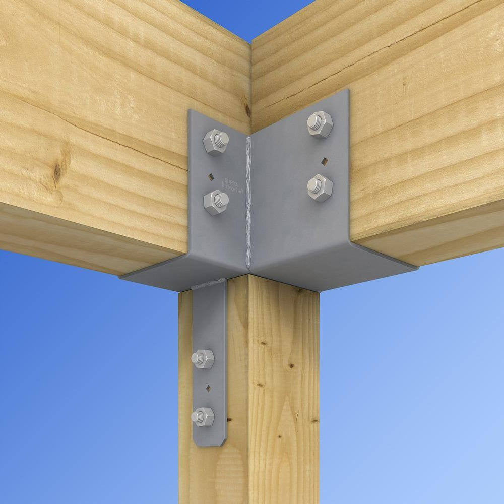 Gray metal L-bracket corner connector bolted to wooden beams and posts with silver hex bolts, shown against a blue sky background.