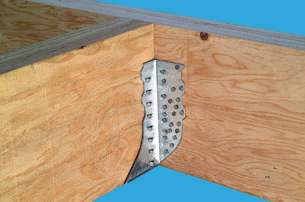 Metal bracket on a wooden frame against a blue background