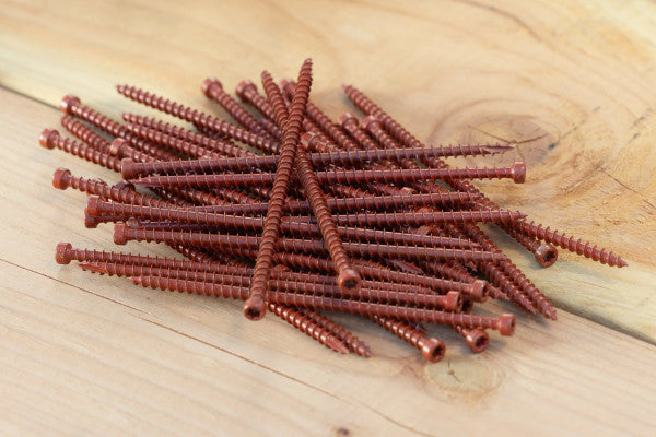 Red screws on a wooden surface