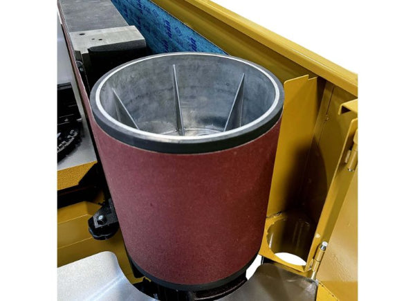 Red sanding drum on a yellow machine with a white background
